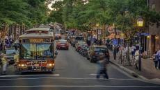A person crossing the street in front of trolley in the King Street shopping and entertainment district of Alexandria, Virginia, USA.