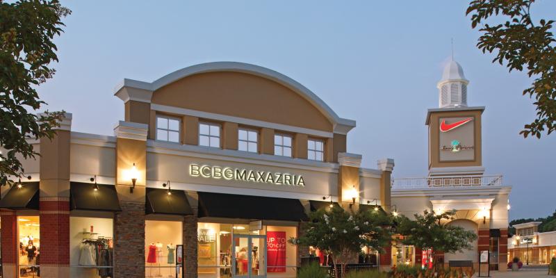 The facade of Queenstown Premium Outlets shopping centre in Queenstown, Maryland, is illuminated at dusk.