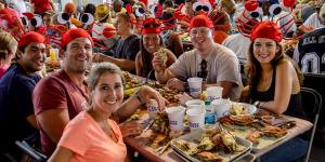 A group of people wearing crab hats enjoying the feast